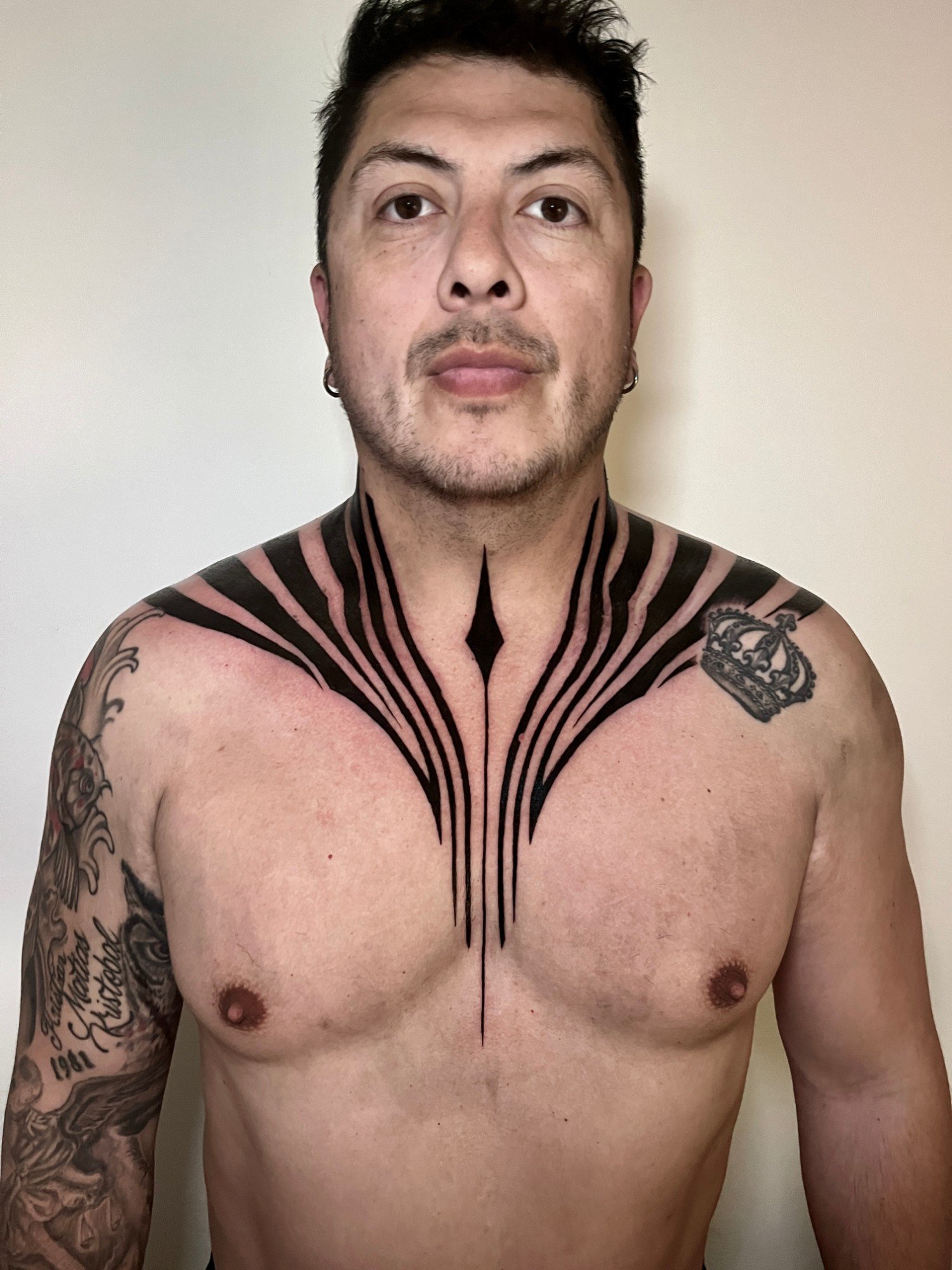 Tatuaje geométrico de líneas radiales en negro sólido sobre pecho y cuello