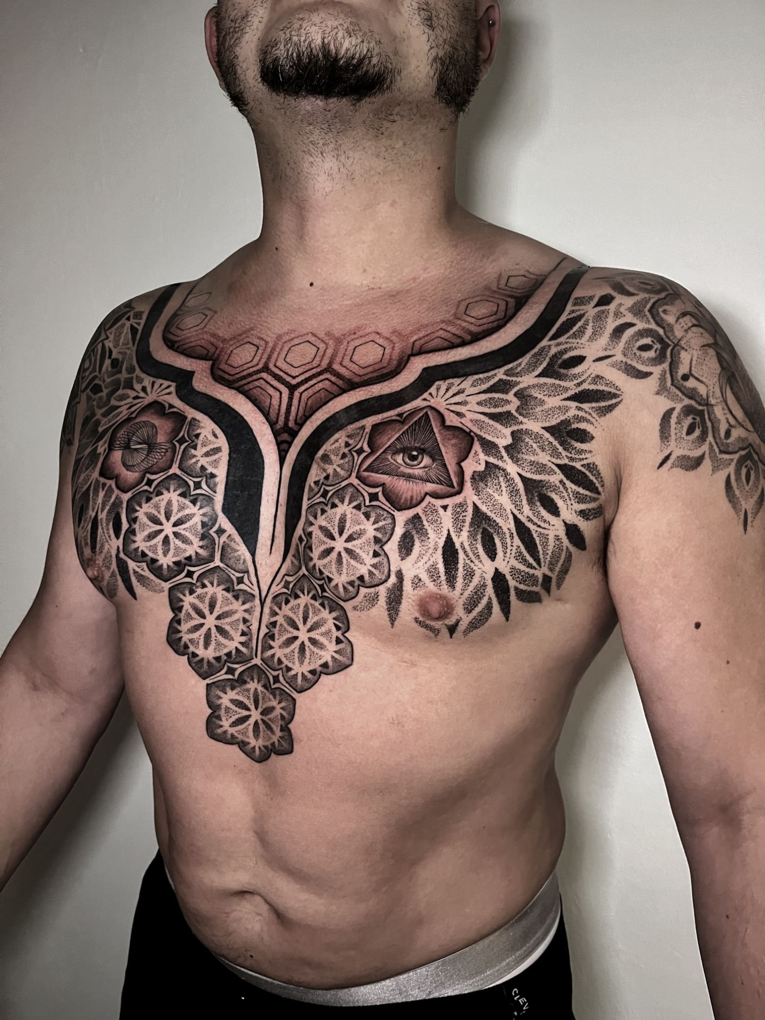 Mandalas florales en dotwork sobre pecho y cuello